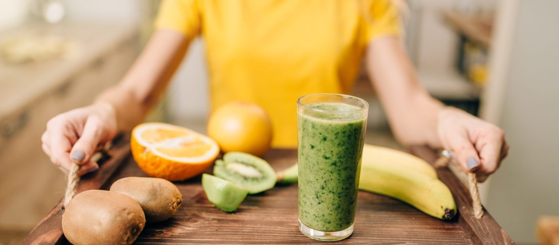 Female person holding a tray with cocktail, fruits and vegetables, cooking  organic food. Vegetarian diet, healthy lifestyle concept